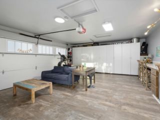 Custom Garage Makeover with Storage and Lounge – Mahtomedi, MN Spacious Mahtomedi garage transformed into a multi-purpose room with wall-to-wall storage cabinets, a cozy sofa, workout equipment, and a bar-height workspace.