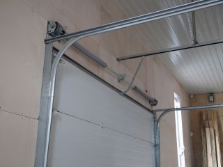 Professional Overhead Garage Door Installation – Mahtomedi, MN Interior view of a newly installed sectional overhead garage door with steel tracks and torsion spring system in a Mahtomedi residential garage.