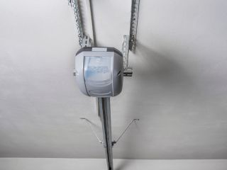 Ceiling-Mounted Automatic Garage Door Opener – Mahtomedi, MN Close-up view of a modern automatic garage door opener mounted on the ceiling, showing the rail and motor system in a Mahtomedi garage.