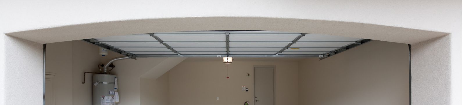 Spacious, clean two-car garage with an open overhead door, showing a well-maintained floor and organized utility area.